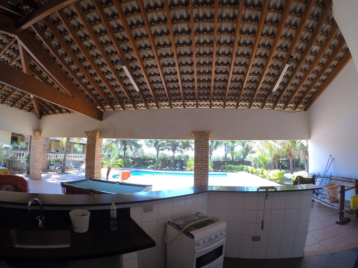 Espaço gourmet do Rancho em Cardoso com mesa de bilhar, churrasqueira e vista para a piscina